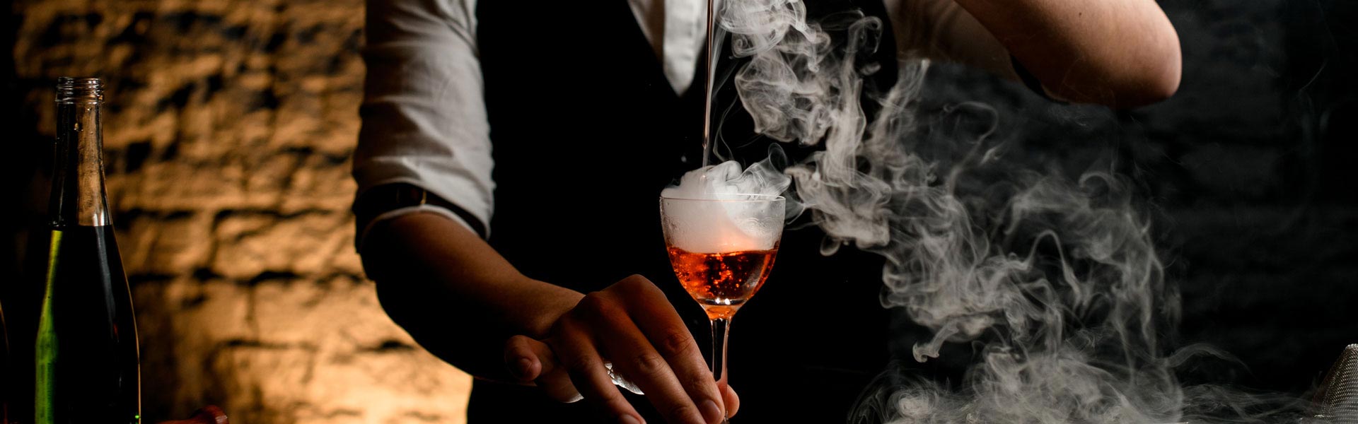A CIA Halloween-themed dining event with a person holding red wine as smoke swirls nearby.