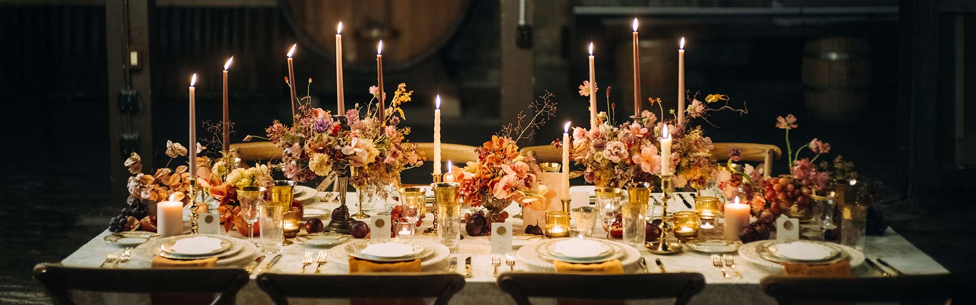 A CIA at Greystone Halloween dining event table with floral centerpieces, candles, and elegant dinnerware.