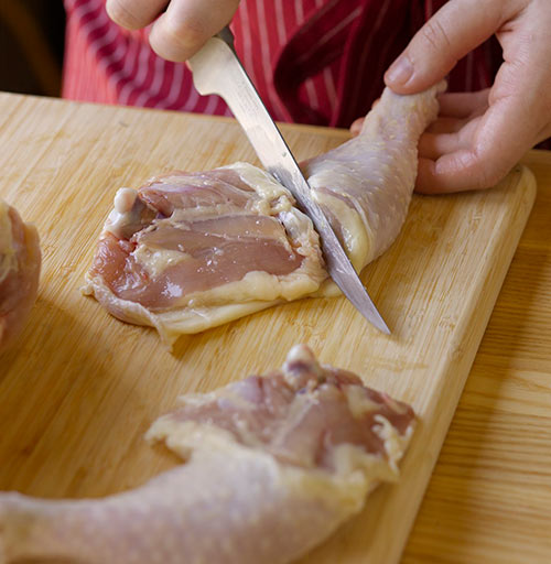 Cutting chicken thighs from the leg quarter