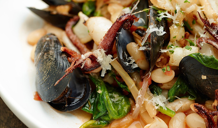 Sauteed Squid and Steamed Mussels with Cannellini Beans, Spinach, and Pancetta. From the 'Cooking at Home' cookbook.