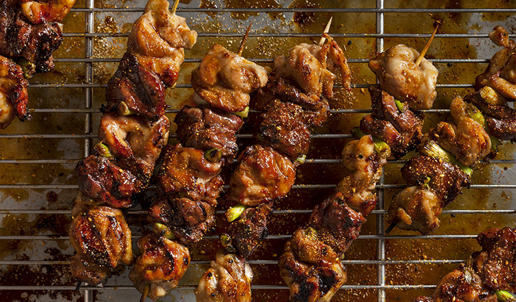 Skewered grilled chicken resting on a rack