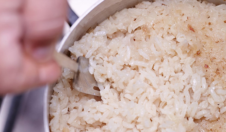 Fluffing a pot of rice pilaf with a fork