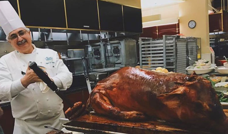 chef in CIA kitchen carving a roasted pig