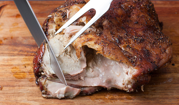 Use a kitchen fork to steady the roast while you carve the meat with a large slicing knife.