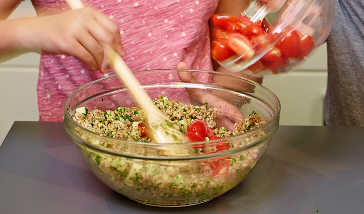 Mixing a farro caprese salad
