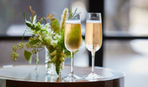 champagne glasses on a table with flowers