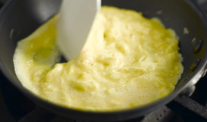 Scrambling eggs in a non-stick pan.