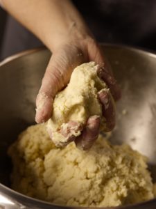 Pie dough pressed in hand and holding its shape.