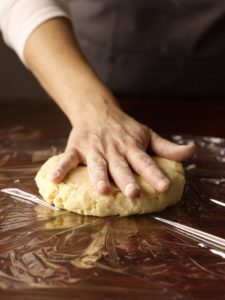 Pie dough formed into a disc ready to wrap in plastic wrap.