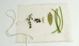 Ingredients for a standard sachet d'épices, or "bag of spices." Aromatic ingredients, encased in cheesecloth, that are used to flavor stocks and other liquids. A standard sachet contains parsley stems, cracked peppercorns, dried thyme, and a bay leaf.
