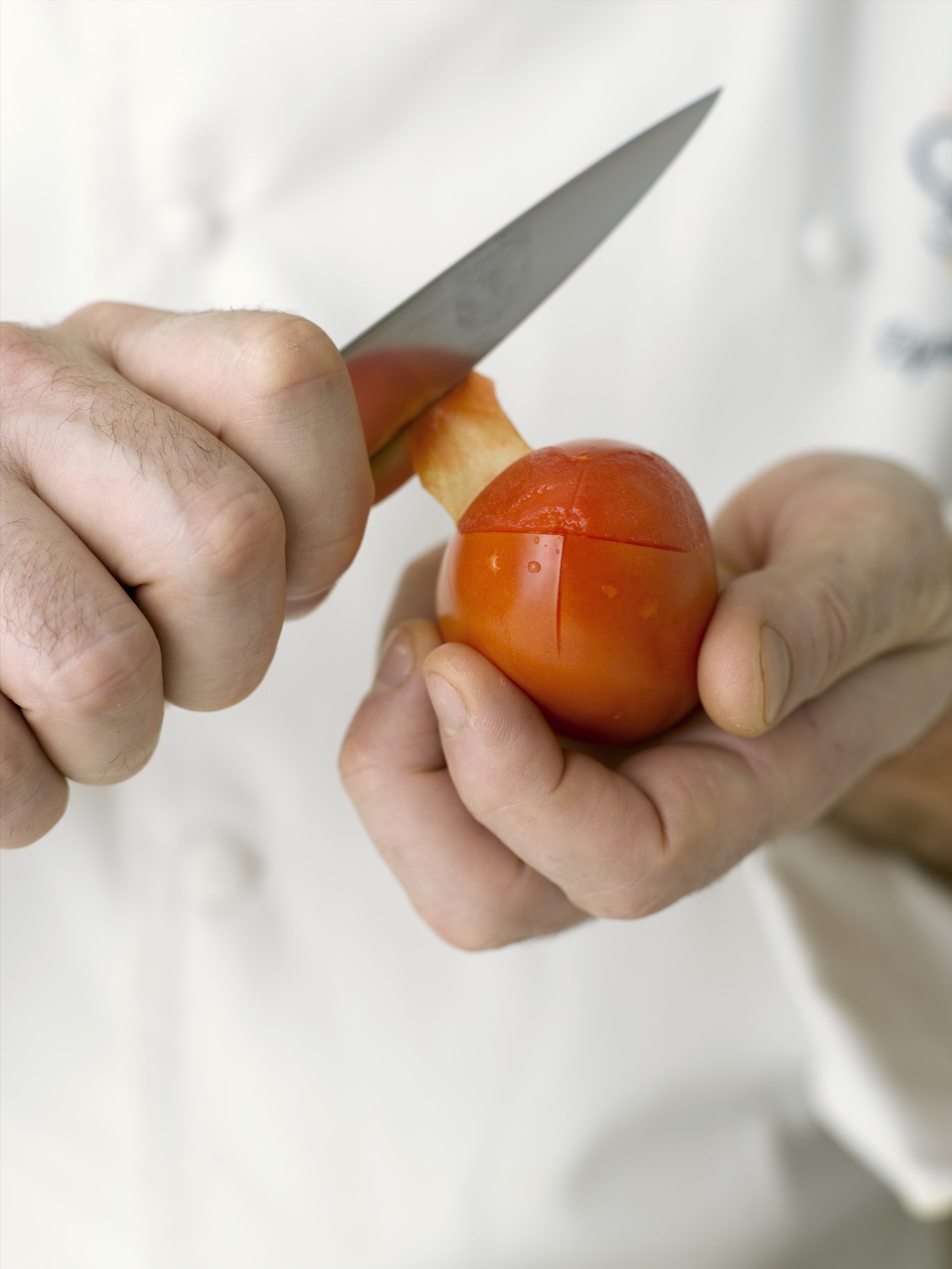 Peel away the skin of the tomato.