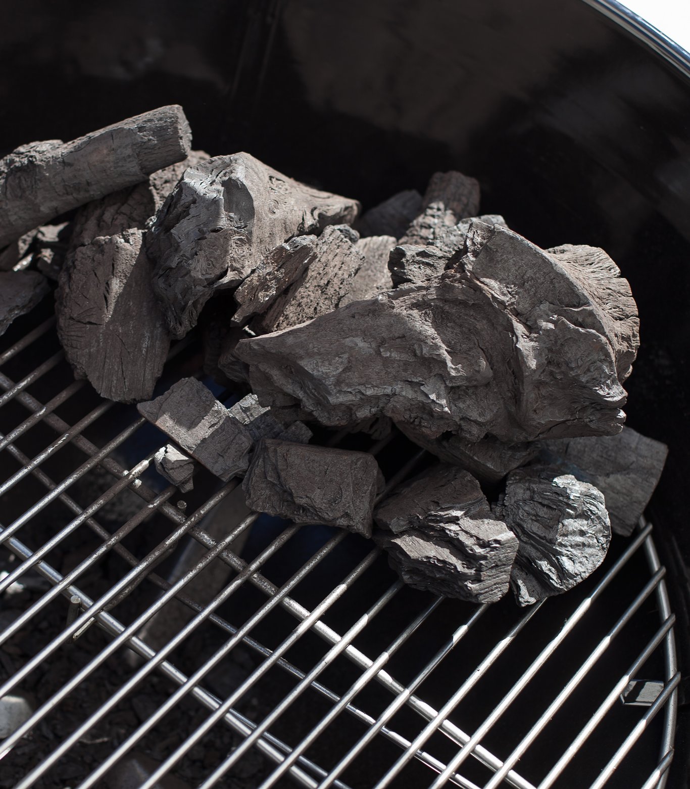 Charcoal arranged on one side of a grill for indirect cooking.