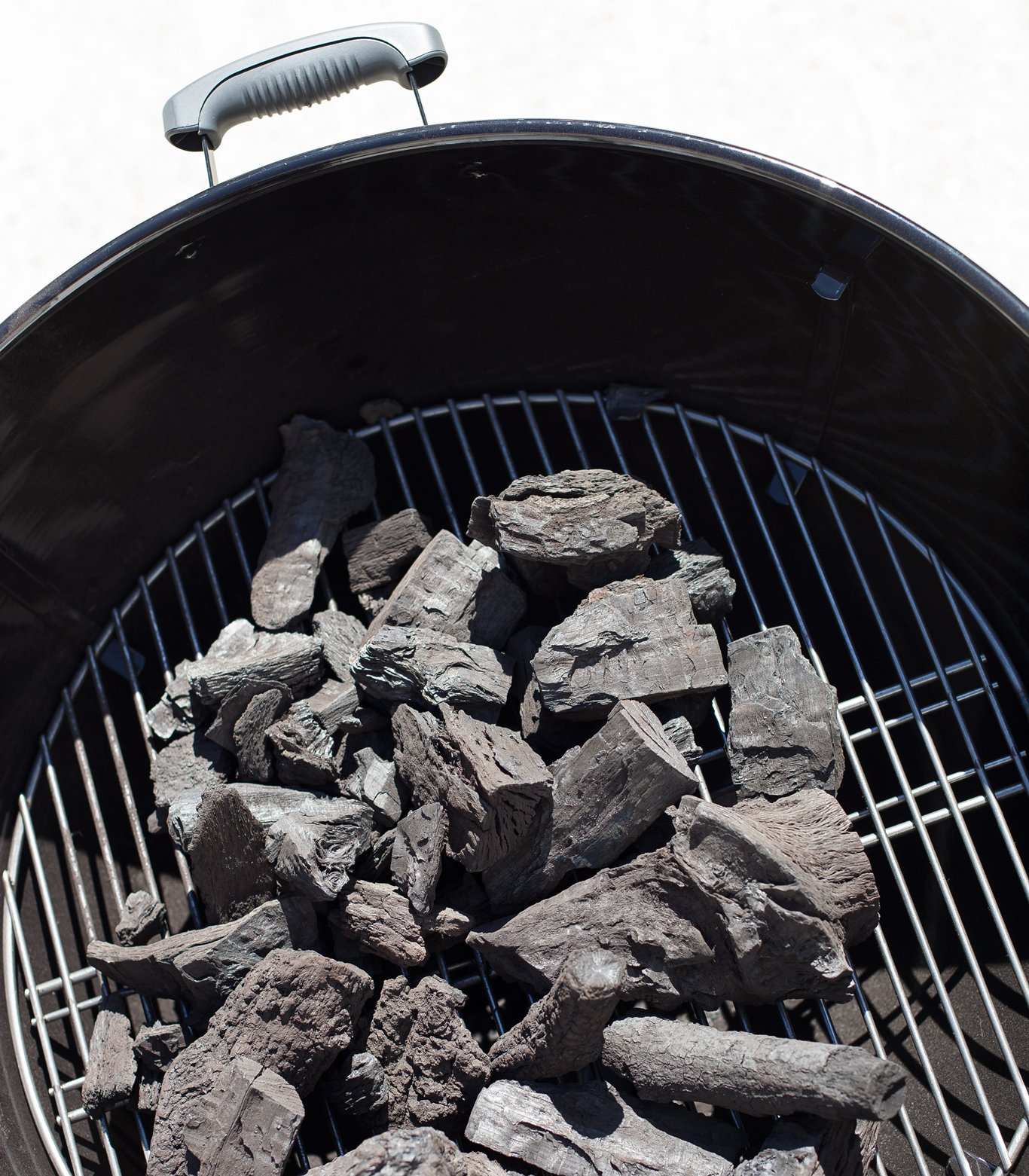 Coals arranged in the center of a grill.