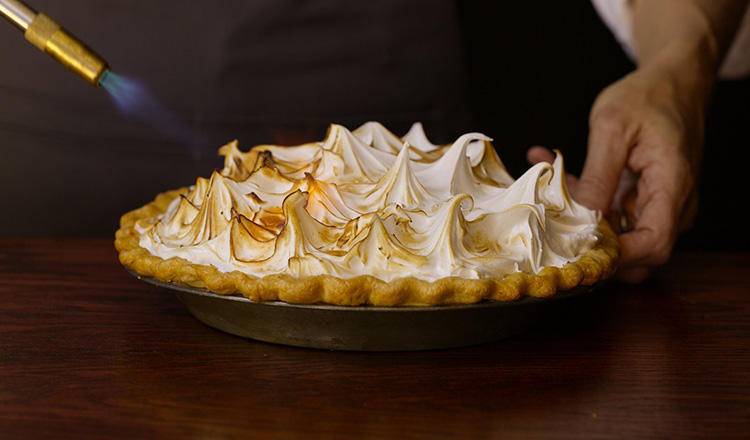 Use a culinary torch to evenly brown the exterior of a meringue topping.