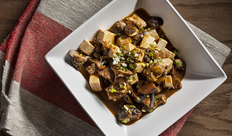 Spicy tofu with mushrooms garnished with green onions