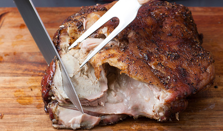 Use a kitchen fork to steady the roast while you carve the meat with a large slicing knife.