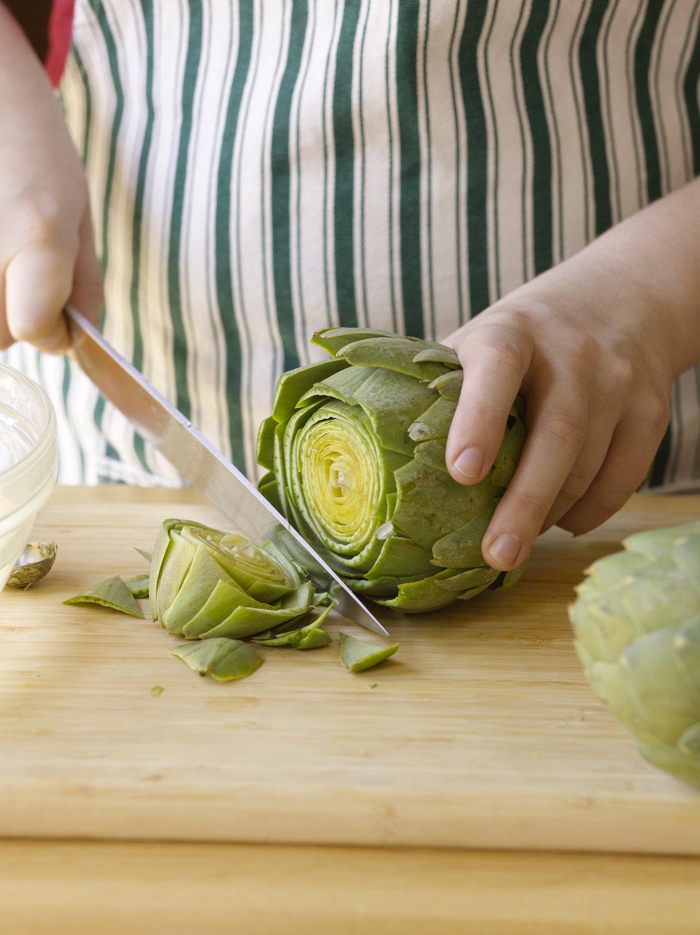 Remove the top and excess stem of the artichoke.