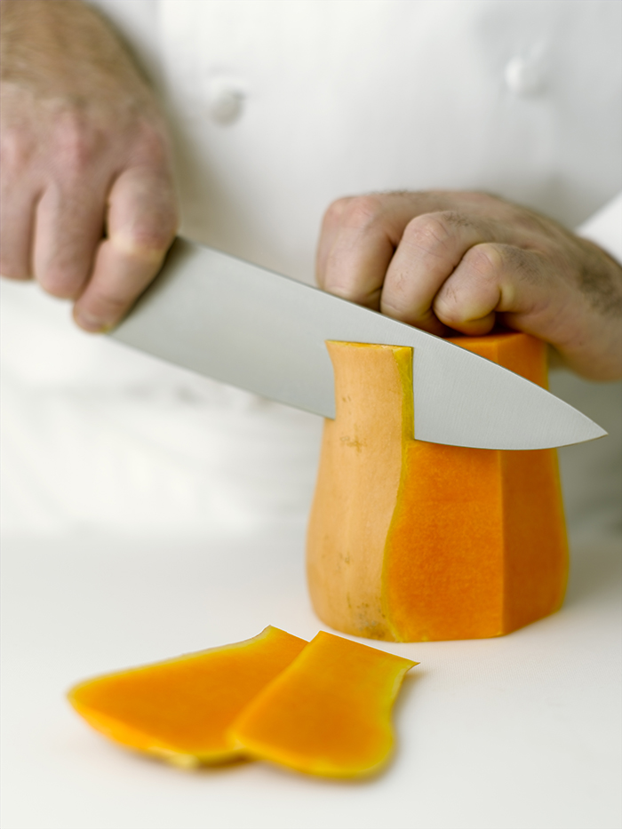 Peeling a thick-skinned  winter squash with a chef's knife.