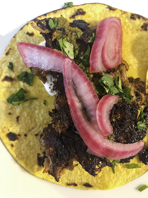 Pork taco with cilantro and pickled onion