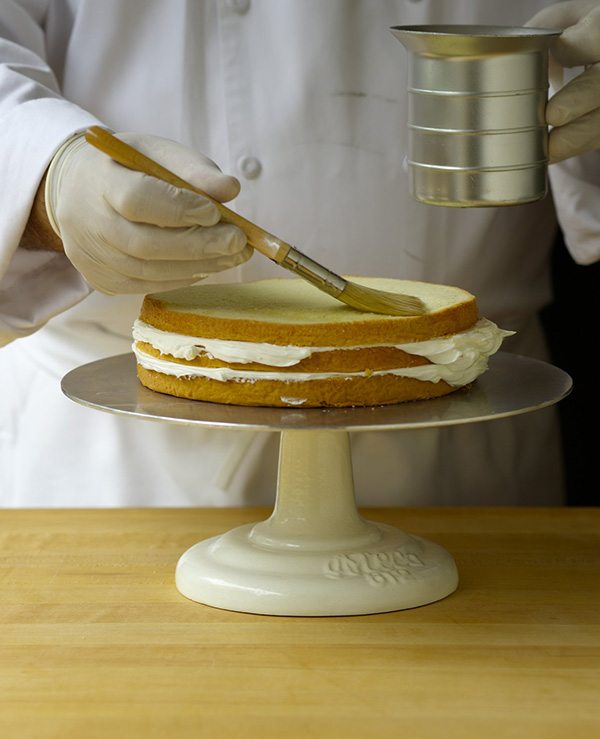 Soak the cut cake layers lightly with simple syrup.