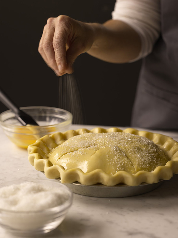 Use a pastry brush to apply an egg wash. Sprinkle the pie with sanding sugar.