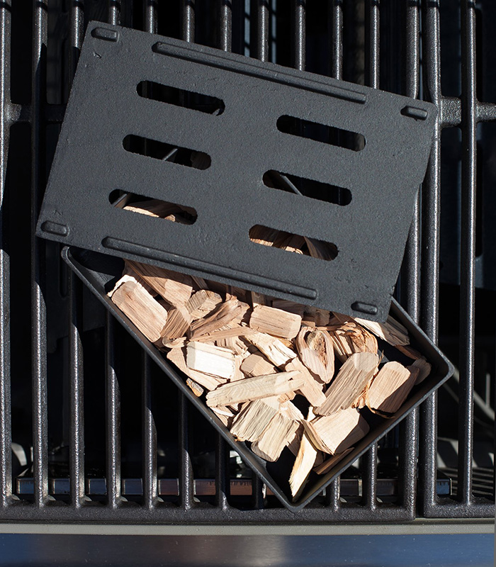 A smoke box filled with wood chips allows a gas grill to produce fragrant wood smoke.