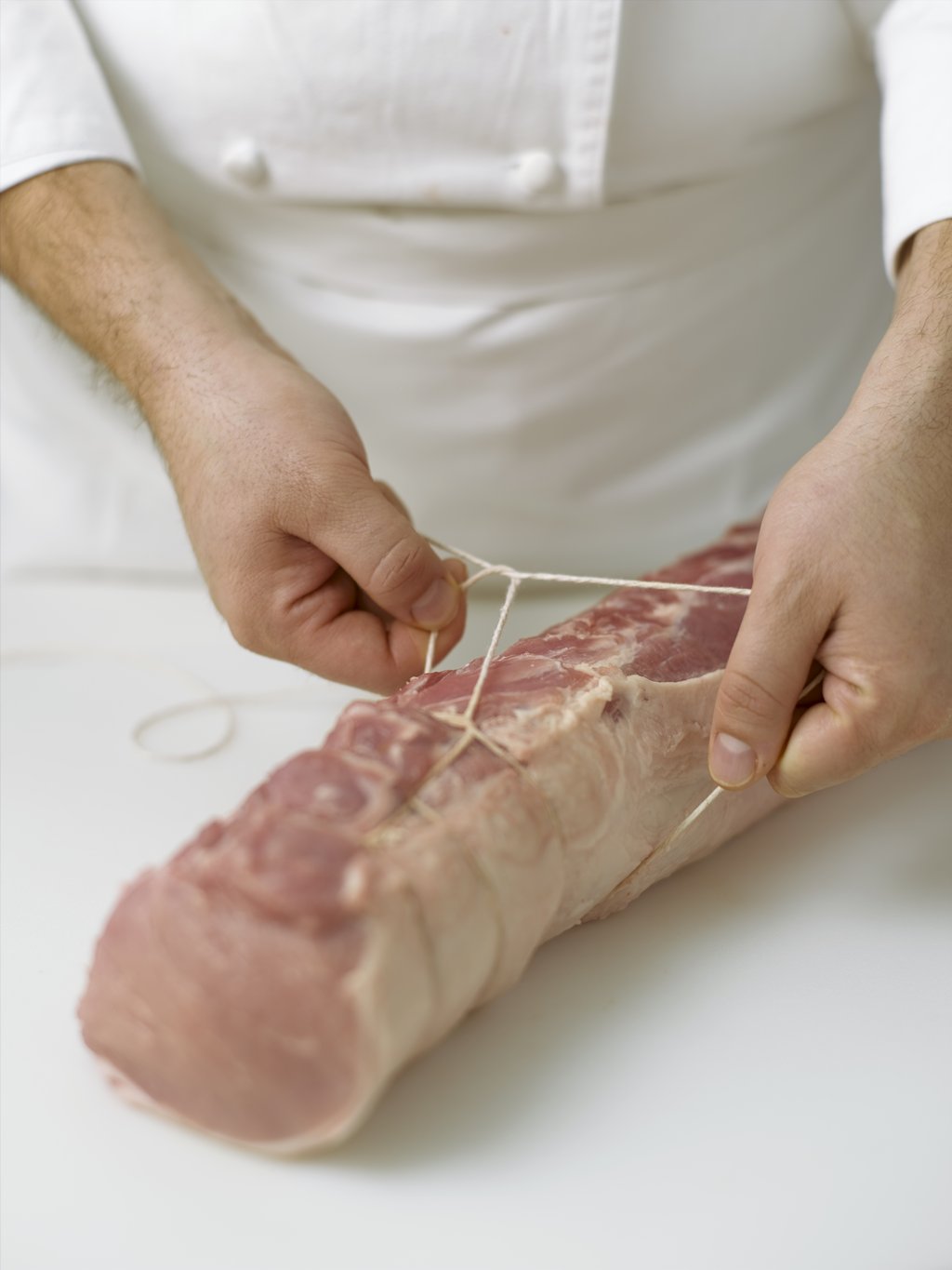 Step four: Encircle the meat with the loop, making sure that the knots are spaced evenly apart from one another.