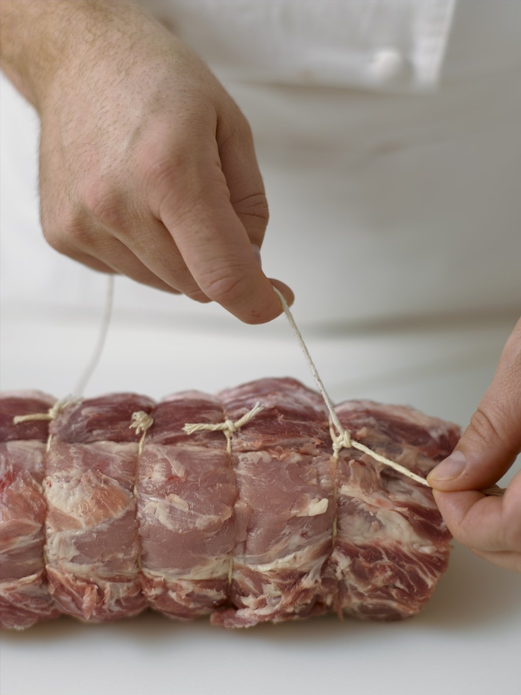 Tying string on a pork roast