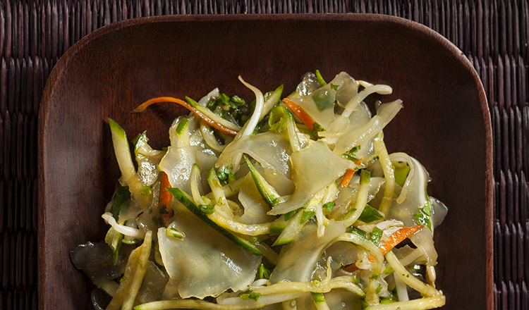 Mung bean starch sheets with carrots, squash, zucchini and soy bean in a wood square dish
