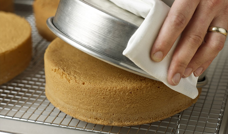 Releasing Vanilla Sponge Cake from the pan onto the cooling rack.