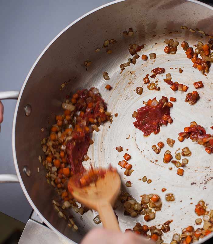 Cooking tomato paste with vegetables