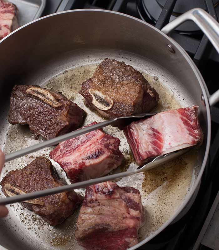searing beef short ribs in a pot