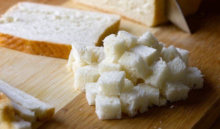 cutting bread for homemade croutons