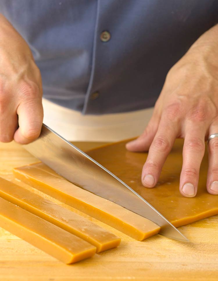 Cutting a slab of caramel into strips