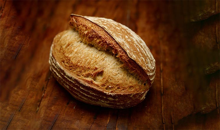 Loaf of sourdough on wood board