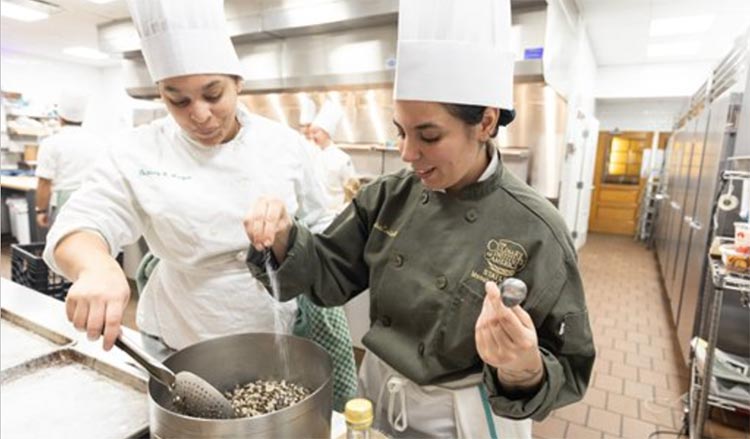 Chef and student cooking at the stove