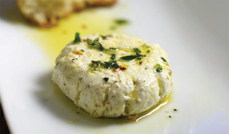 herb-marinated goat cheese on a white plate