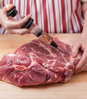 Injecting brine into a pork shoulder