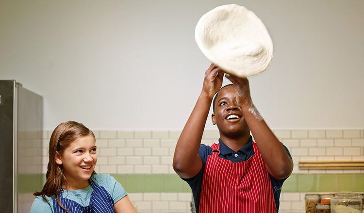 Young man tossing pizza dough