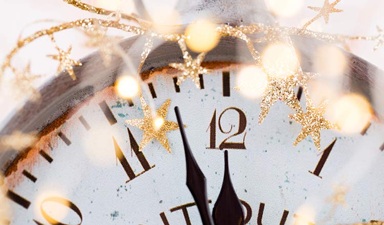 Clock at midnight with lights and ribbon