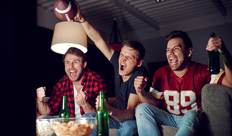 Fans watching football at home on the couch