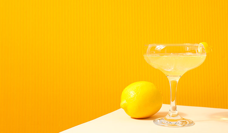 Glass of limoncello against a yellow backdrop