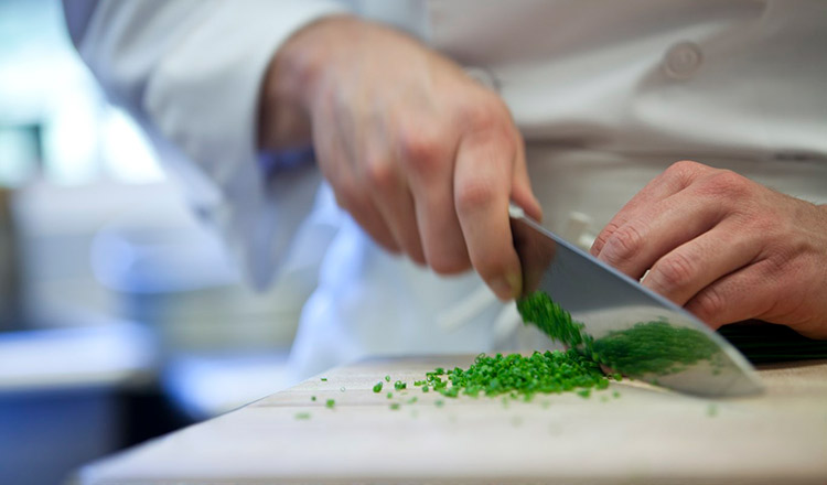 Mincing herbs on a wood board