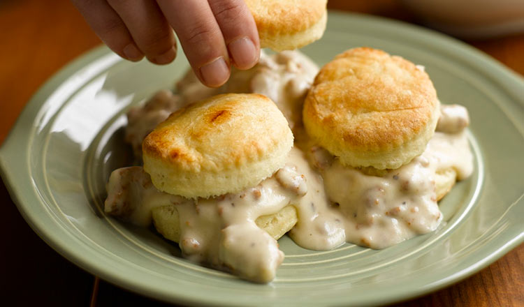 Biscuits with creamy sausage gravy on a green plate