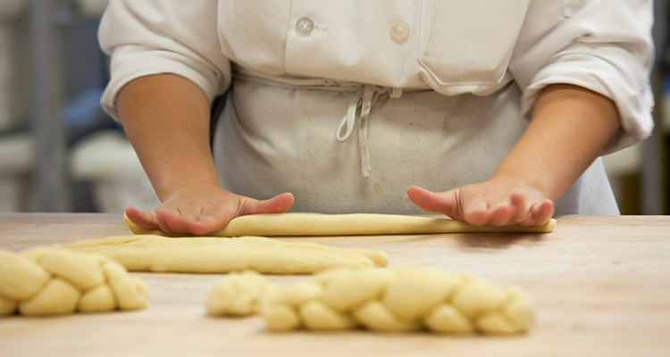 Rolling dough on a wooden workbench