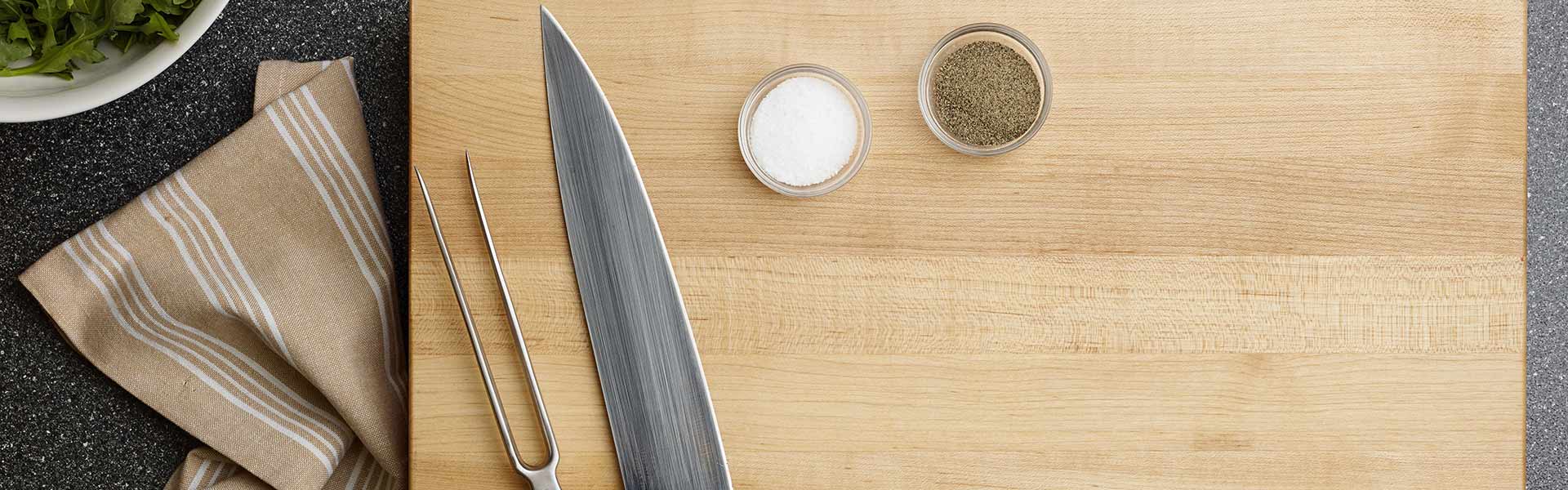 Cutting board with knives, salt, and pepper