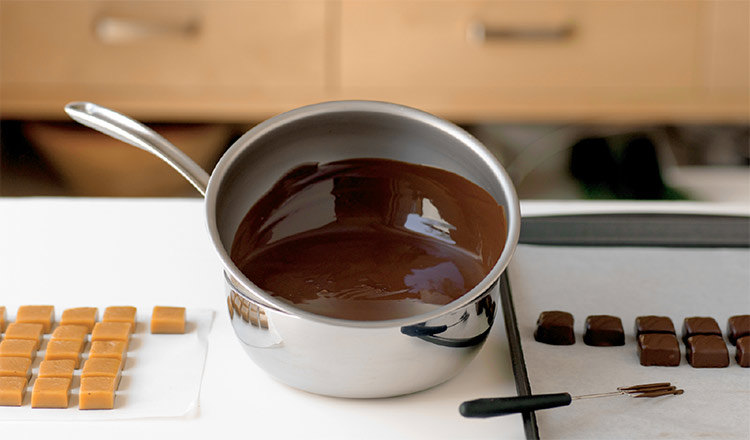 Station set up to dip caramel centers in chocolate.