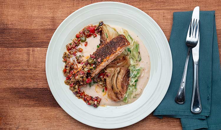 Photo of fennel seed crusted salmon with white bean and roasted garlic purée, caramelized fennel and spring onions with olive and roasted pepper relish.
