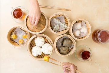 Table full of dim sum in bamboo steamers.