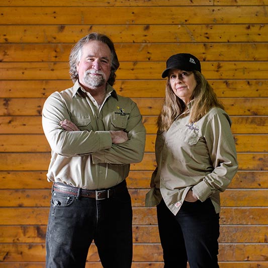 Dennis and Jeanette Nesel - New York Malt: The Soul of Beer mage of Dennis and Jeanette Nesel standing in front of a wood wall.
